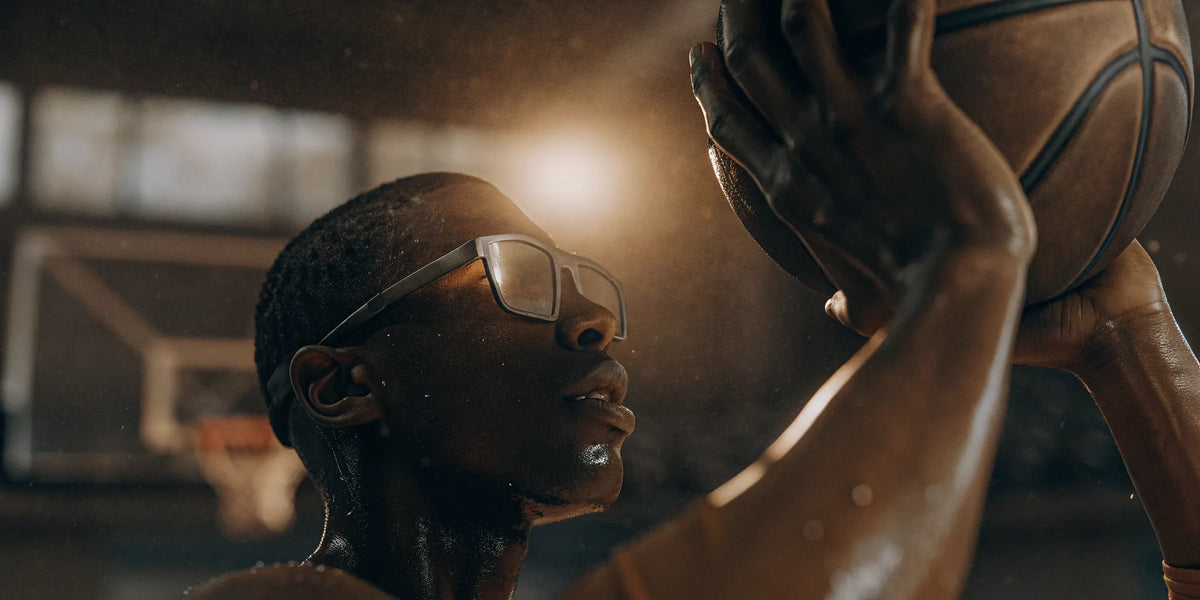 Basketball player wearing shooting glasses takes a shot.