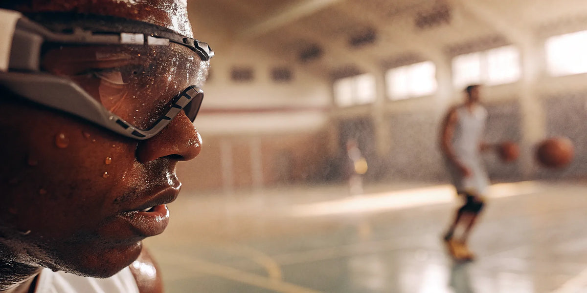 Basketball player works on dribbling with training goggles to keep their head up and improve court vision.