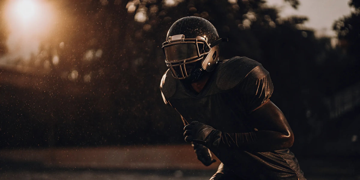 Football player in a helmet trains with peripheral vision blocking goggles.