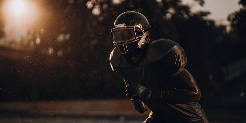 Football player in a helmet trains with peripheral vision blocking goggles.