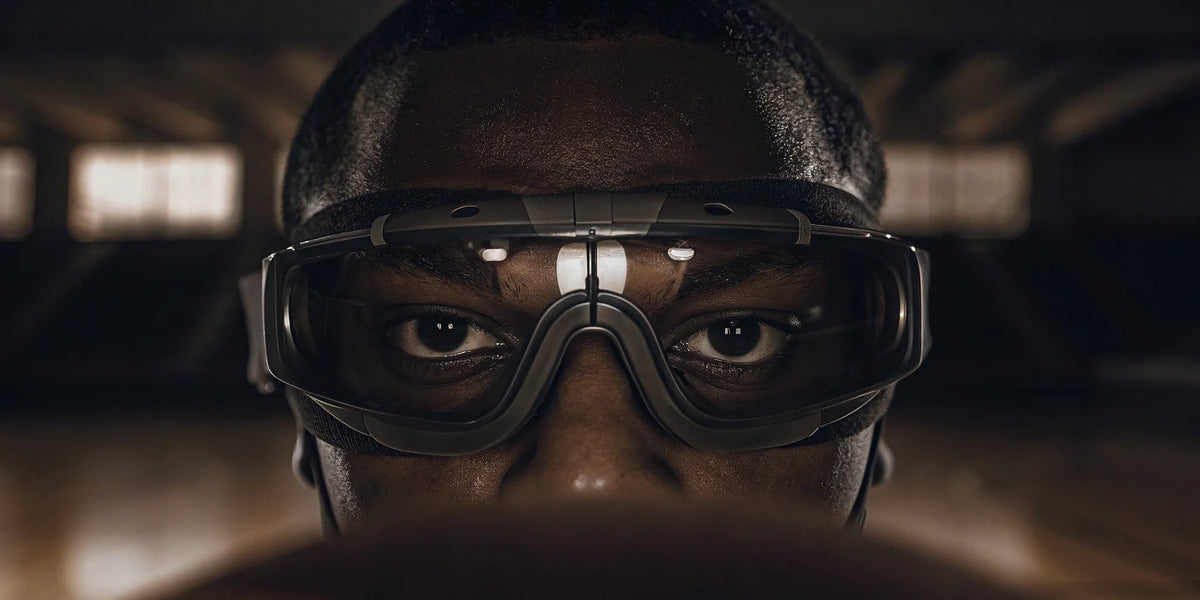 Close-up of a basketball player wearing vision training goggles on the court.