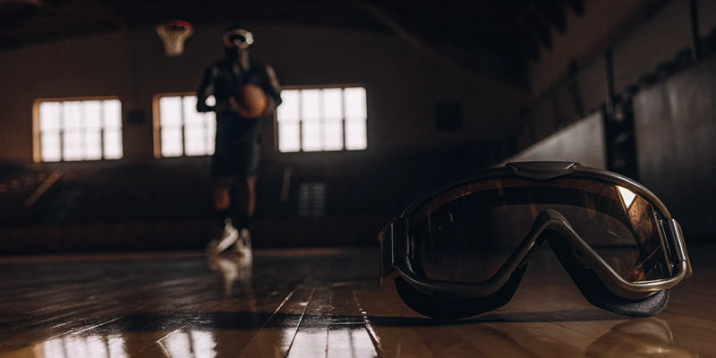 Dribble goggles for basketball training on a court with a player in the background.