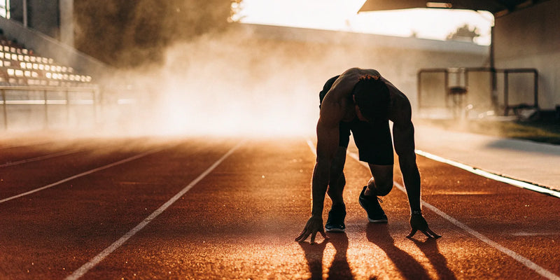 A focused athlete prepares to sprint using mental training tools you can buy.